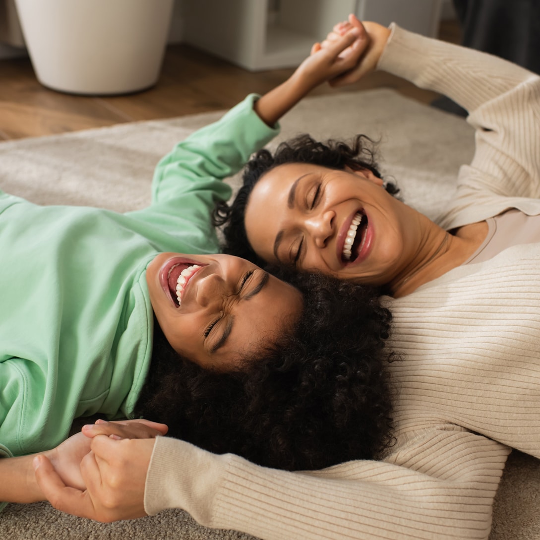 mother and daughter laughing on the floor in wisconsin