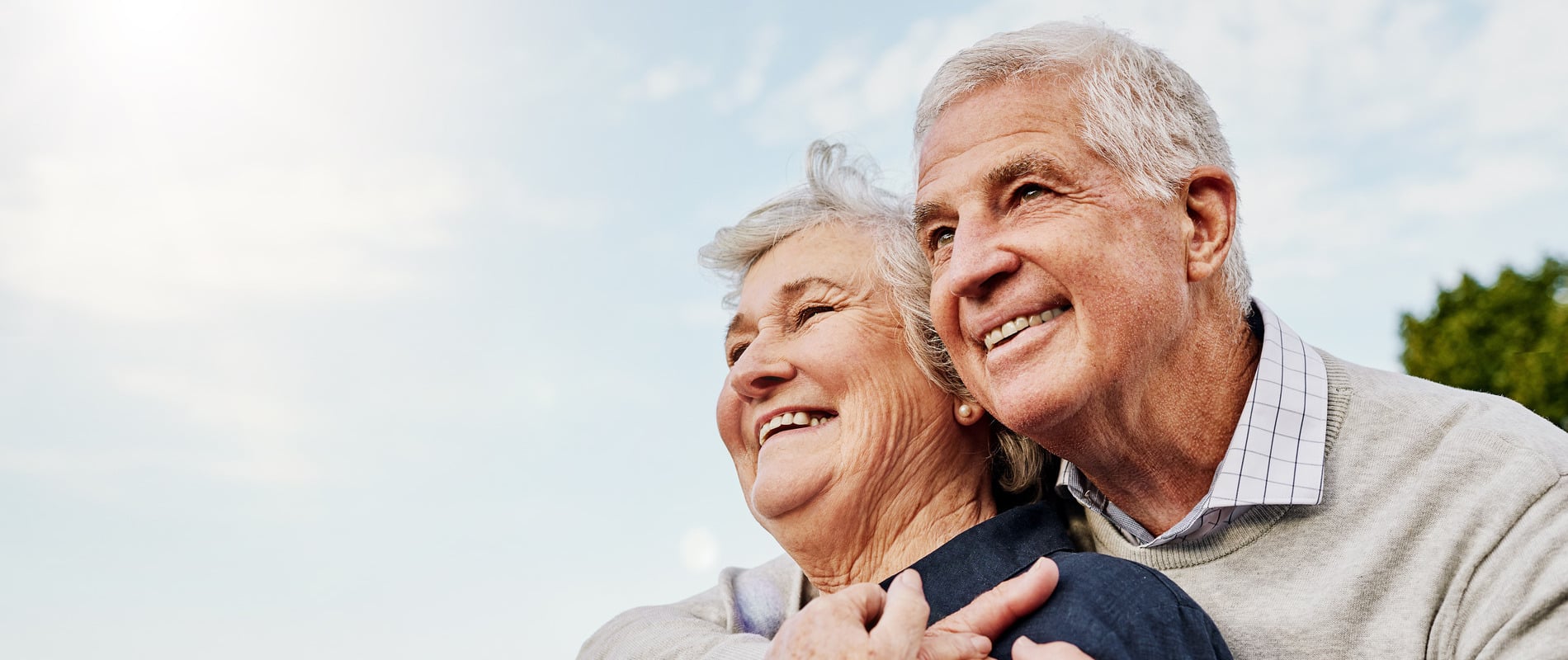 An older coulple hugging after they recieved dental implant surgery in Mount Pleasant MI